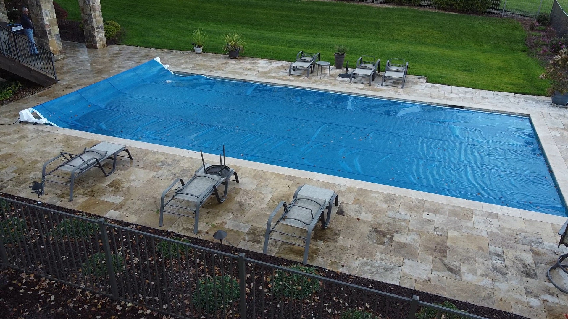 Automatic motorised pool cover being deployed over a residential swimming pool